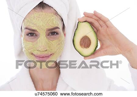 Young woman holding half an avocado wearing face mask, studio shot. View Large Photo Image Stock Image - Young woman holding half an avocado wearing face mask, studio shot.. Fotosearch