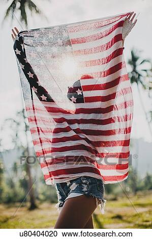 Young woman holding up American flag, Krabi, Thailand View Large Photo Image Stock Image - Young woman holding up American flag, Krabi, Thailand. Fotosearch