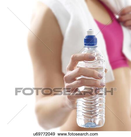 Young woman holding water bottle, studio shot. View Large Photo Image Stock Photo - Young woman holding water bottle, studio shot.. Fotosearch