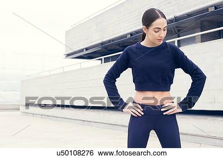 Stock Photograph - Young woman in sports clothes with hands on hips.. Fotosearch