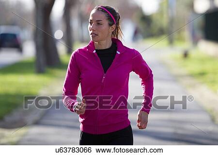 Stock Photograph - Young woman jogging. Fotosearch