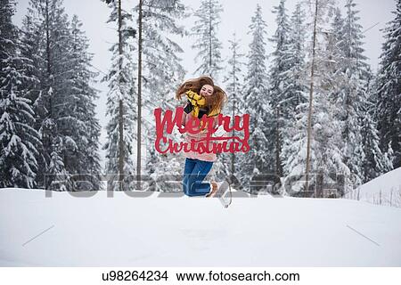 Young woman jumping with Merry Christmas words in snow View Large Photo Image Picture - Young woman jumping with Merry Christmas words in snow. Fotosearch