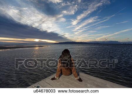 Young woman looking out from pier at sunset, Tarragona, Catalonia, Spain View Large Photo Image Stock Image - Young woman looking out from pier at sunset, Tarragona, Catalonia, Spain. Fotosearch
