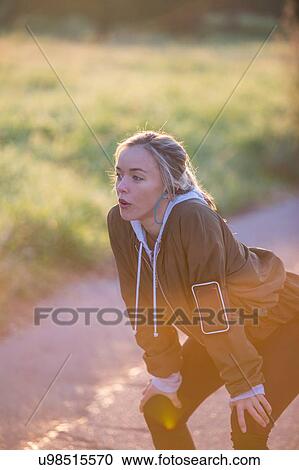 Young woman outdoors, taking a break from exercising, hands on knees View Large Photo Image Stock Image - Young woman outdoors, taking a break from exercising, hands on knees. Fotosearch