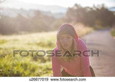 Young woman outdoors, taking a break from exercising View Large Photo Image Stock Photo - Young woman outdoors, taking a break from exercising. Fotosearch