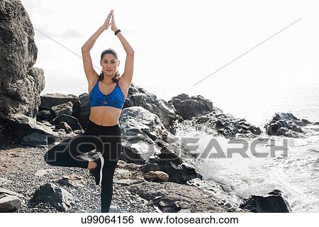 Stock Photograph - Young woman practicing yoga standing tree pose on beach, Las Palmas, Canary Islands, Spain. Fotosearch