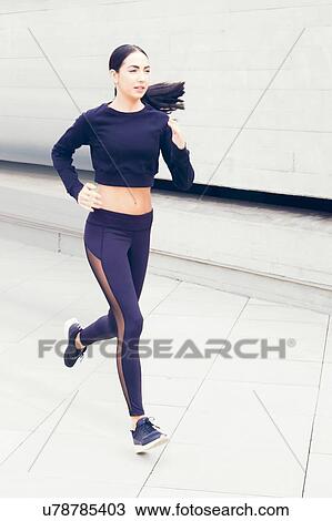 Young woman running by building. View Large Photo Image Stock Image - Young woman running by building.. Fotosearch