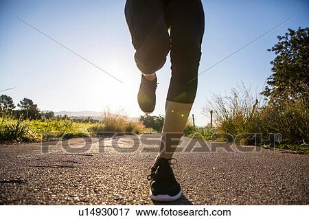 Young woman running outdoors, low section View Large Photo Image Stock Photo - Young woman running outdoors, low section. Fotosearch