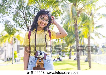 Stock Photo - Young woman sightseeing in park, Bangkok, Thailand. Fotosearch