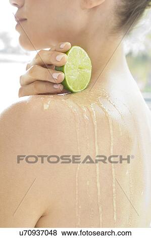 Young woman squeezing fresh lime juice down her back, close up. View Large Photo Image Stock Photo - Young woman squeezing fresh lime juice down her back, close up.. Fotosearch