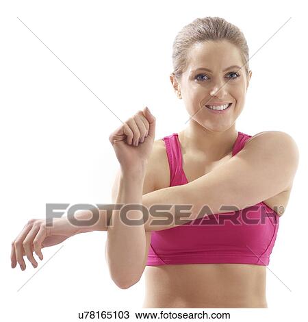 Young woman stretching arm, studio shot. View Large Photo Image Stock Image - Young woman stretching arm, studio shot.. Fotosearch