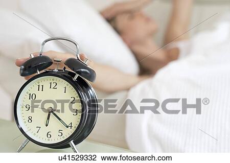 Young woman touching alarm clock. View Large Photo Image Stock Image - Young woman touching alarm clock.. Fotosearch