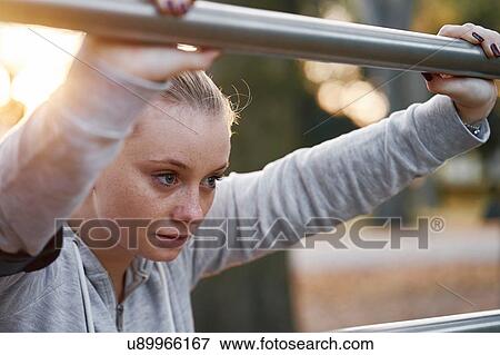 Young woman training, leaning against handrail in park View Large Photo Image Stock Photo - Young woman training, leaning against handrail in park. Fotosearch