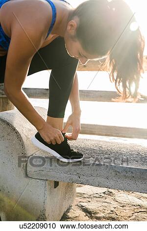 Young woman training on beach, tying trainer laces View Large Photo Image Stock Image - Young woman training on beach, tying trainer laces. Fotosearch