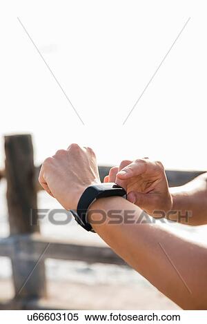 Young woman training on sea waterfront looking at smartwatch, close up of hands View Large Photo Image Stock Photography - Young woman training on sea waterfront looking at smartwatch, close up of hands. Fotosearch