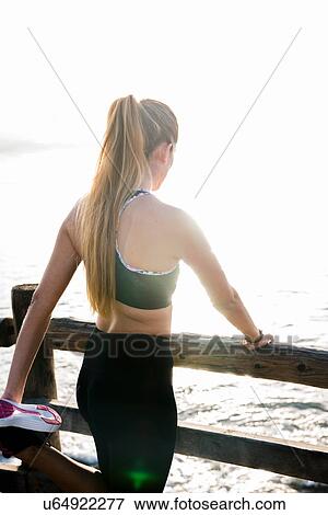 Young woman training on waterfront, warming up View Large Photo Image Stock Photo - Young woman training on waterfront, warming up. Fotosearch