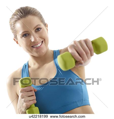 Young woman using hand weights, studio shot. View Large Photo Image Stock Photo - Young woman using hand weights, studio shot.. Fotosearch