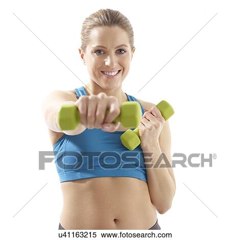 Stock Photography - Young woman using hand weights, studio shot.. Fotosearch