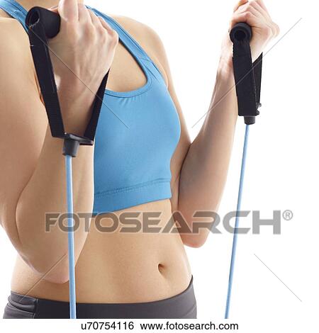 Young woman using resistance band, studio shot. View Large Photo Image Stock Photograph - Young woman using resistance band, studio shot.. Fotosearch