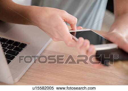 Young woman using smartphone at desk, close up of hands View Large Photo Image Stock Photography - Young woman using smartphone at desk, close up of hands. Fotosearch
