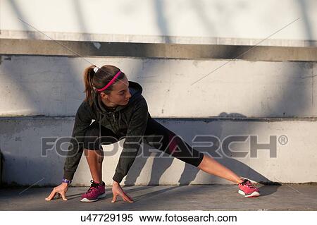 Young woman warming up, stretching legs View Large Photo Image Stock Photography - Young woman warming up, stretching legs. Fotosearch