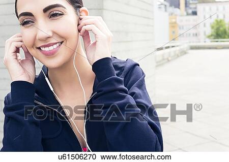 Young woman wearing earphones, smiling. View Large Photo Image Stock Image - Young woman wearing earphones, smiling.. Fotosearch