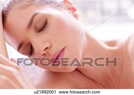 Stock Image - Young woman with eyes closed, portrait.. Fotosearch