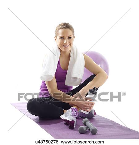 Stock Photograph - Young woman with sports equipment and towel, smiling towards camera.. Fotosearch
