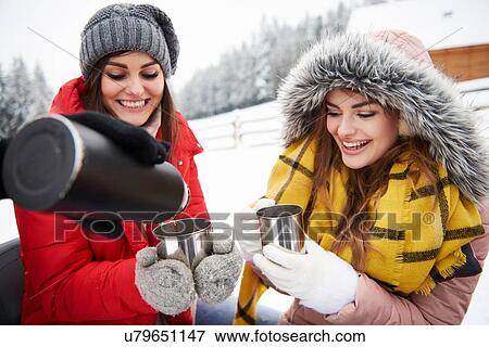 Young women having coffee outdoors in winter View Large Photo Image Stock Photo - Young women having coffee outdoors in winter. Fotosearch