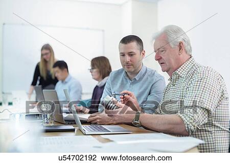 Younger and older scientists discussing pharmaceutical science project in meeting room View Large Photo Image Stock Image - Younger and older scientists discussing pharmaceutical science project in meeting room. Fotosearch