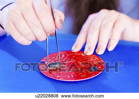 Stock Photo - Adding components to printed circuit board.. Fotosearch