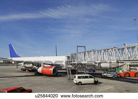 Airliner docking at passenger bridge, maintenance cars arriving for fuel View Large Photo Image Stock Image - Airliner docking at passenger bridge, maintenance cars arriving for fuel. Fotosearch