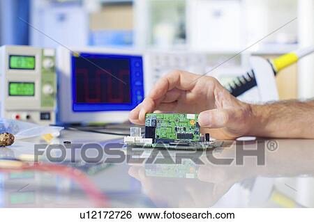 Stock Photograph - Assembling electronics device.. Fotosearch