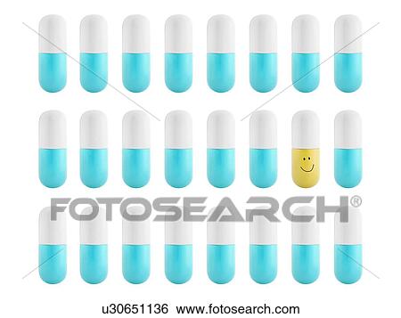 Stock Photograph - Blue and white capsules and one yellow and white capsule, studio shot.. Fotosearch