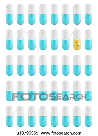 Stock Photography - Blue and white capsules and one yellow and white capsule, studio shot.. Fotosearch