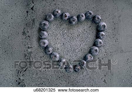 Stock Photography - Blueberries in heart shape against grey background.. Fotosearch