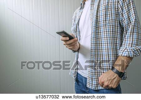 Bored casual man in plaid shirt using mobile phone to waste time. View Large Photo Image Stock Image - Bored casual man in plaid shirt using mobile phone to waste time.. Fotosearch