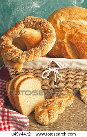 Stock Image - Bread and rolls in a wicker basket.. Fotosearch