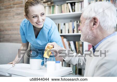 Care worker and senior man with medicine bottle. View Large Photo Image Picture - Care worker and senior man with medicine bottle.. Fotosearch