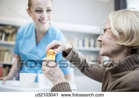 Care worker and senior woman opening medicine bottle. View Large Photo Image Stock Image - Care worker and senior woman opening medicine bottle.. Fotosearch