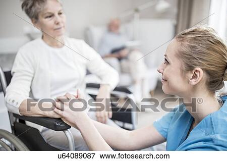 Care worker reassuring senior woman in wheelchair in care home. View Large Photo Image Stock Photo - Care worker reassuring senior woman in wheelchair in care home.. Fotosearch