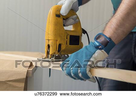 Stock Photo - Carpenter using jigsaw.. Fotosearch