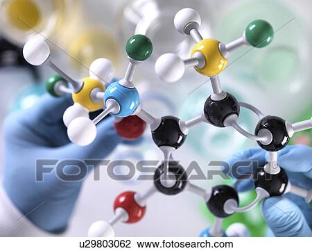 Stock Image - Chemistry research. Researcher designing a chemical formula using a molecular model.. Fotosearch