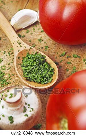 Stock Photo - Chopped parsley on wooden spoon.. Fotosearch