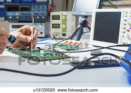 Stock Image - Circuit board repair.. Fotosearch