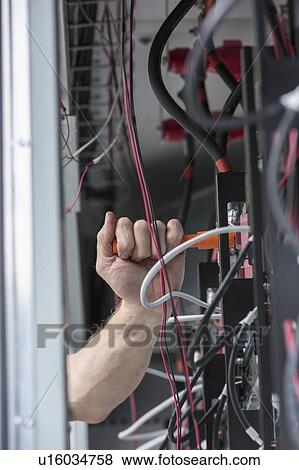 Stock Photo - Close-up of an engineer using a torque wrench on copper bolts.. Fotosearch