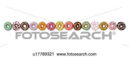 Stock Image - Colourful doughnuts in a row, studio shot.. Fotosearch