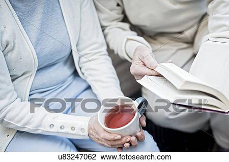 Cropped view of woman with teacup and man holding book. View Large Photo Image Stock Image - Cropped view of woman with teacup and man holding book.. Fotosearch