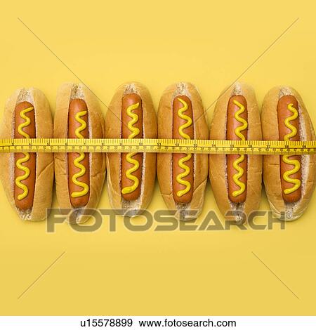 Dieting, conceptual image. Measuring tape around hot dogs. View Large Photo Image Stock Photo - Dieting, conceptual image. Measuring tape around hot dogs.. Fotosearch