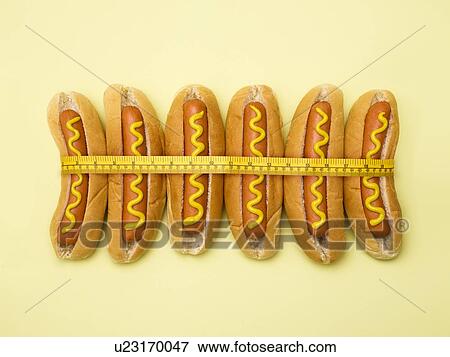 Dieting, conceptual image. Measuring tape around hot dogs. View Large Photo Image Stock Photo - Dieting, conceptual image. Measuring tape around hot dogs.. Fotosearch